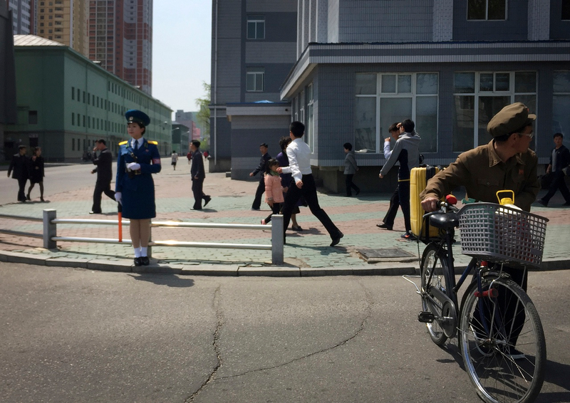 North Korean men and women walk along a residential area in Pyongyang, North Korea on April 25, 2017 (AP Photo/Eric Talmadge)
